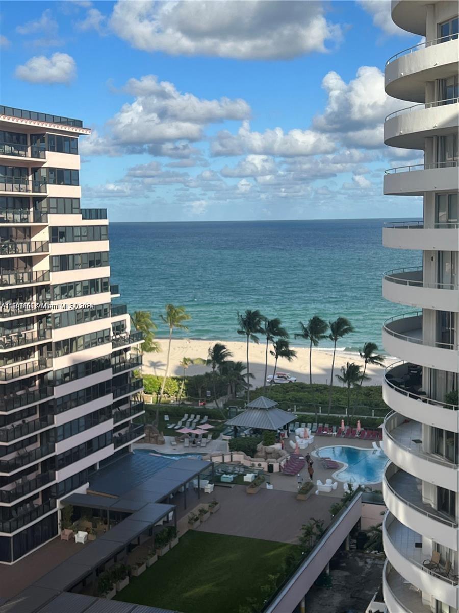 An elevated view shows a beach, ocean, and swimming pool between two high-rise apartment buildings — 5161 COLLINS AVE # 1403, Miami Beach FL 33140, MIAMI BEACH, FL