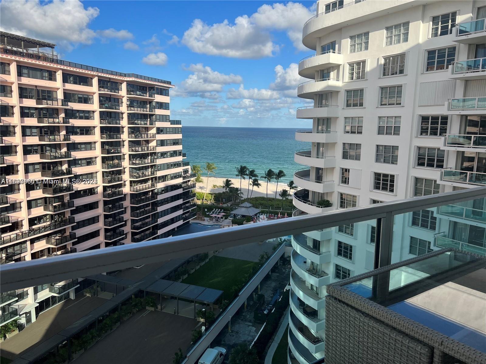 A balcony view overlooks a beach between two large residential apartment buildings — 5161 COLLINS AVE # 1403, Miami Beach FL 33140, MIAMI BEACH, FL