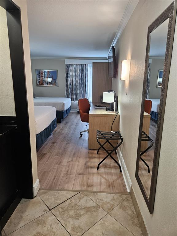 A hotel room features two beds, a desk with an orange chair, and wood flooring — 3000 MAINGATE LANE UNIT 530, KISSIMMEE, FL