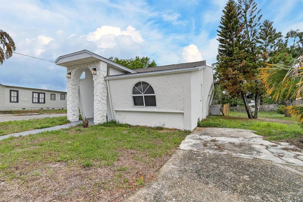 A white house with a stone-accented arched entryway and a single arched window — 800 N CHURCH AVENUE, MULBERRY, FL