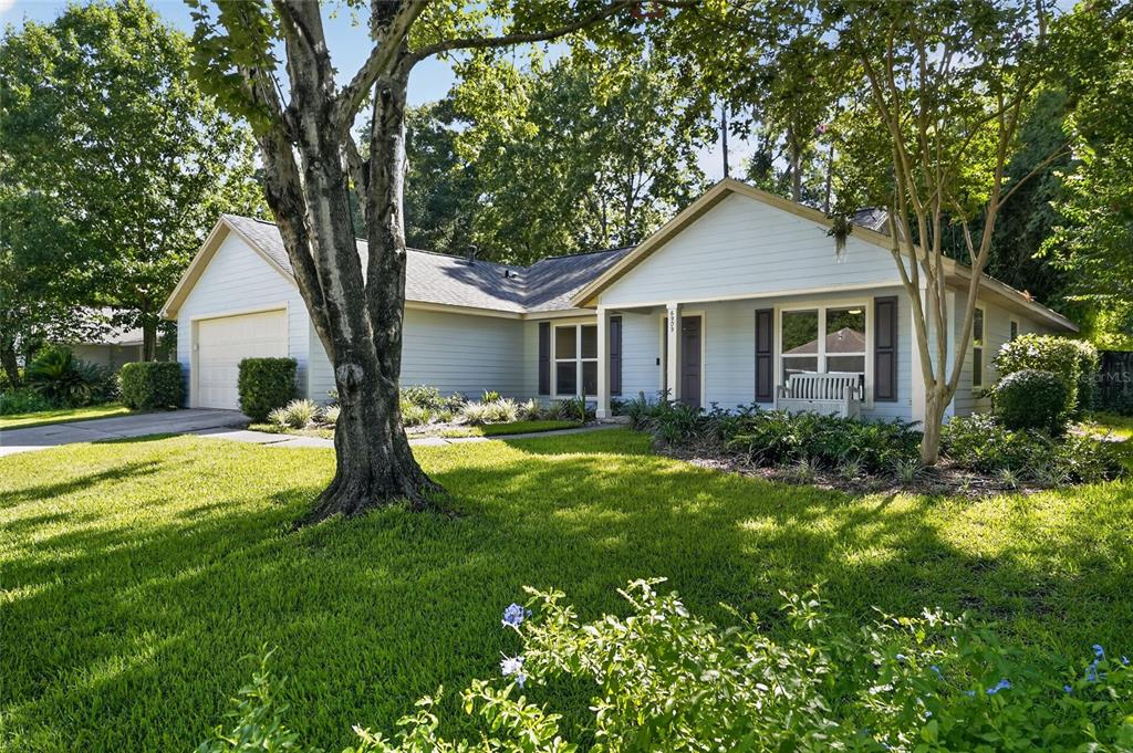 A light blue single-story house with a two-car garage and a front porch — 6909 SW 80TH DRIVE, GAINESVILLE, FL