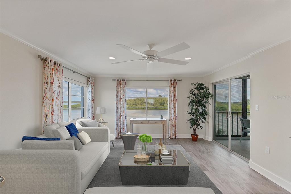 A living room features a gray sofa, a glass coffee table, and views of water — 9397 MIDNIGHT PASS ROAD UNIT 501, SARASOTA, FL