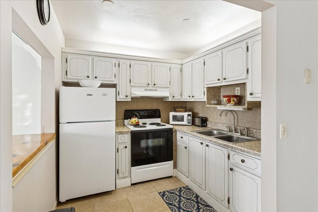 A kitchen with white cabinets, granite countertops, a white refrigerator, and a white electric stove — 95 North Boulevard # 2b, Boynton Beach FL 33435, BOYNTON BEACH, FL