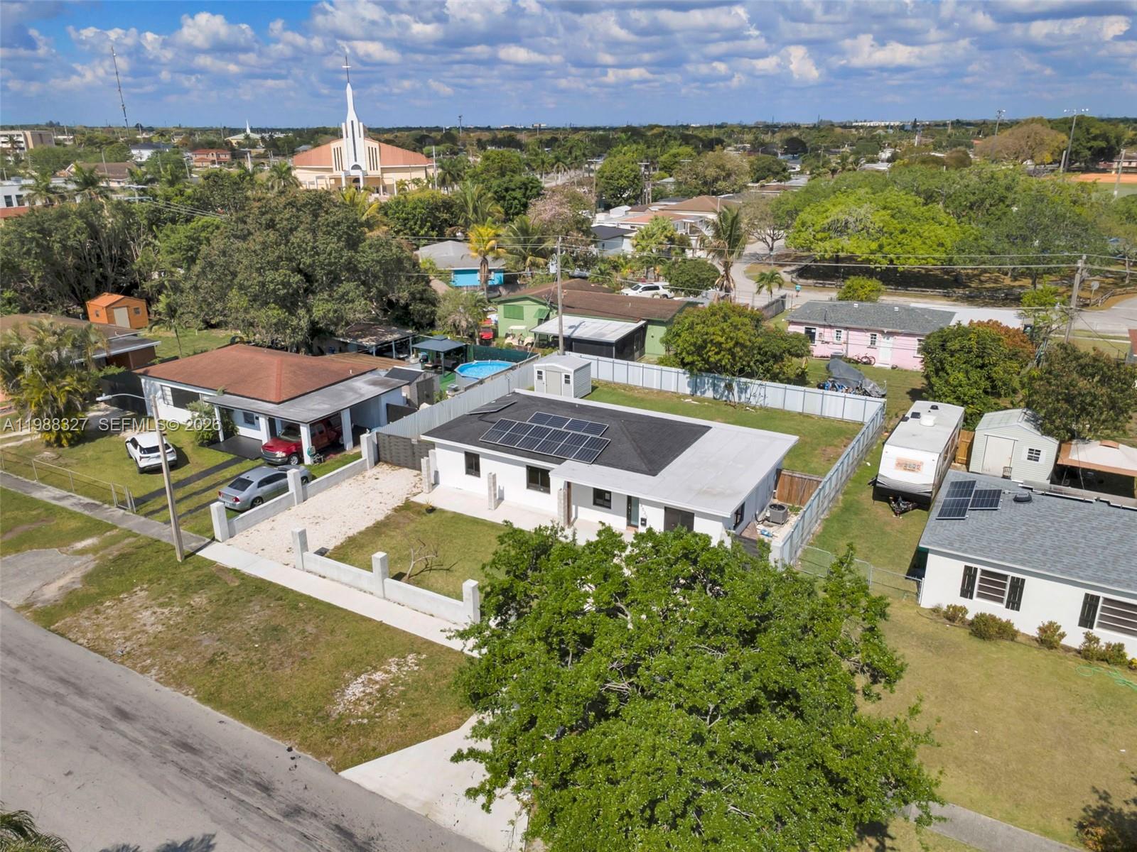 An aerial view shows a white house with solar panels and a fenced backyard — 14520 Carver Drive, Miami FL 33176, MIAMI, FL