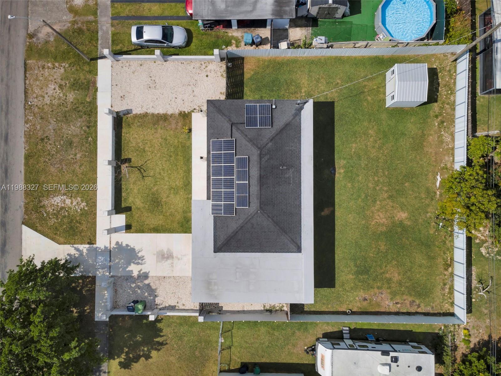 An aerial view shows a house with solar panels on the roof and a backyard — 14520 Carver Drive, Miami FL 33176, MIAMI, FL