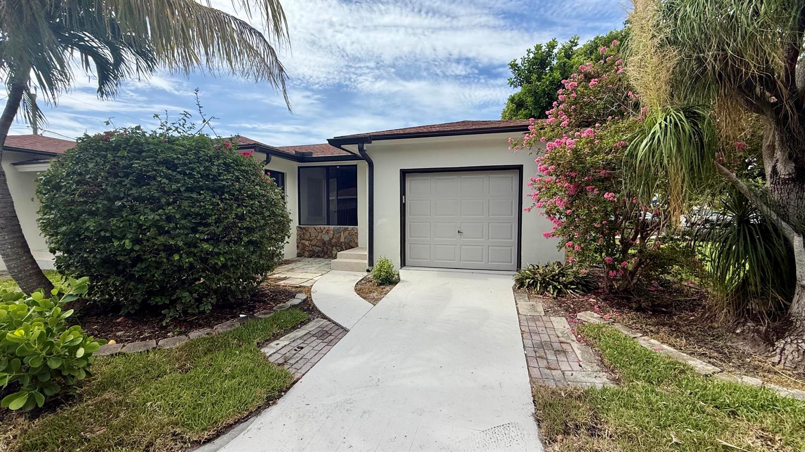 A single-story house with a white exterior, a garage, and a landscaped front yard — 1130 N K Street, FL 33460, FL