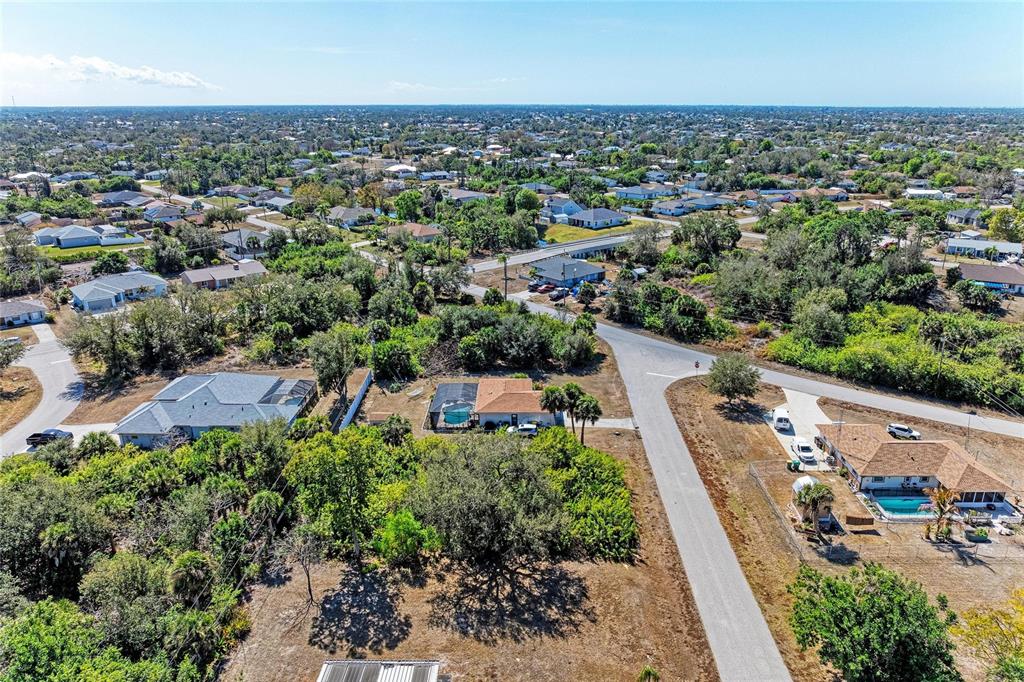 An aerial view shows several suburban houses with swimming pools surrounded by trees and roads — 7376 REGINA DRIVE, ENGLEWOOD, FL