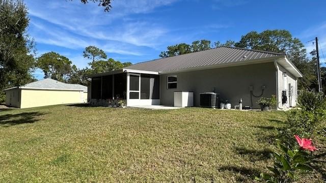 The exterior of a single-story house features a metal roof, a screened porch, and siding — 1113 PORSCHE AVENUE, SEBRING, FL