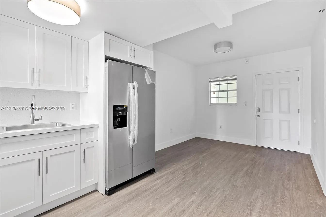 A kitchen features white cabinets, a stainless steel refrigerator, and light wood-look flooring — 1351 SW 4th St # 8, Miami FL 33135, MIAMI, FL