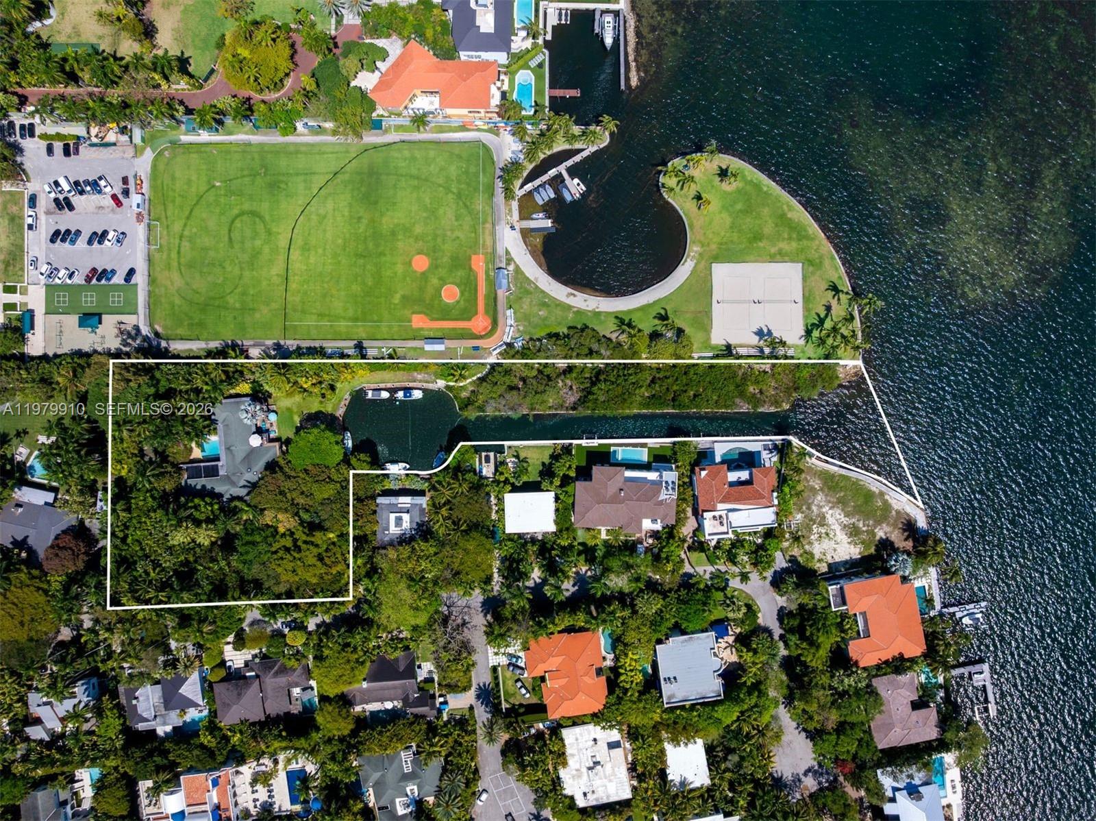 This aerial view shows a waterfront residential property with a private canal and pool — 3373 Poinciana Ave, Miami FL 33133, MIAMI, FL