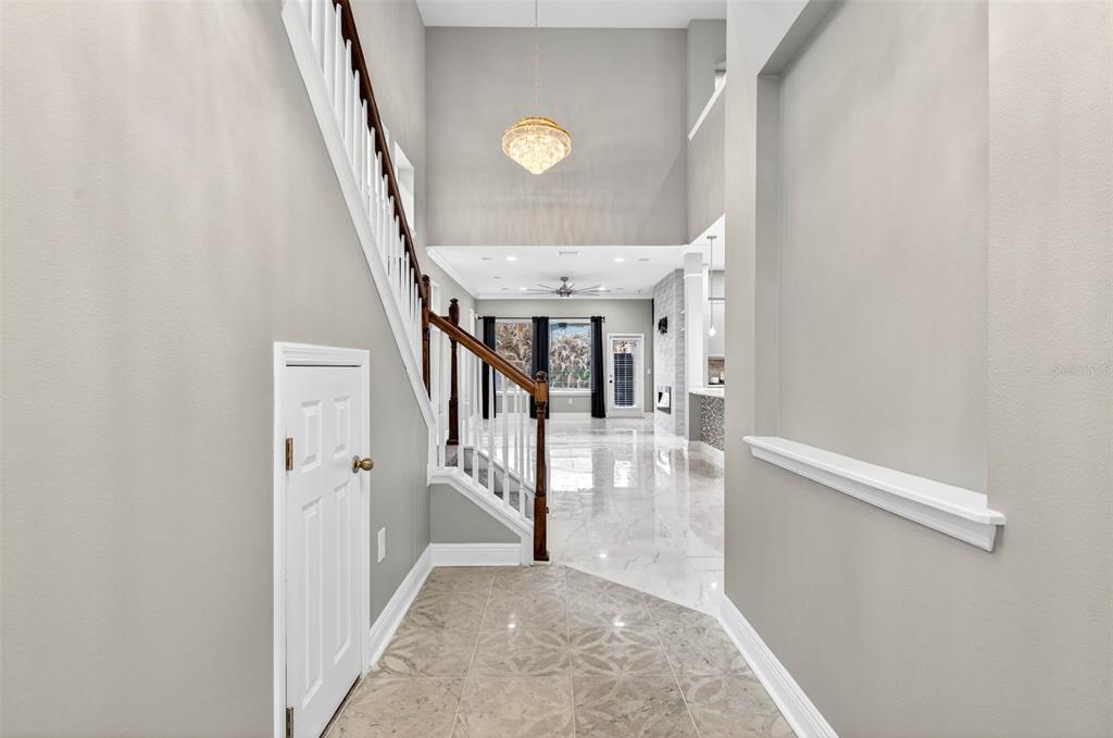 A foyer with a staircase, tile flooring, and a view into an open living area — 14310 BARRINGTON STOWERS DRIVE, LITHIA, FL