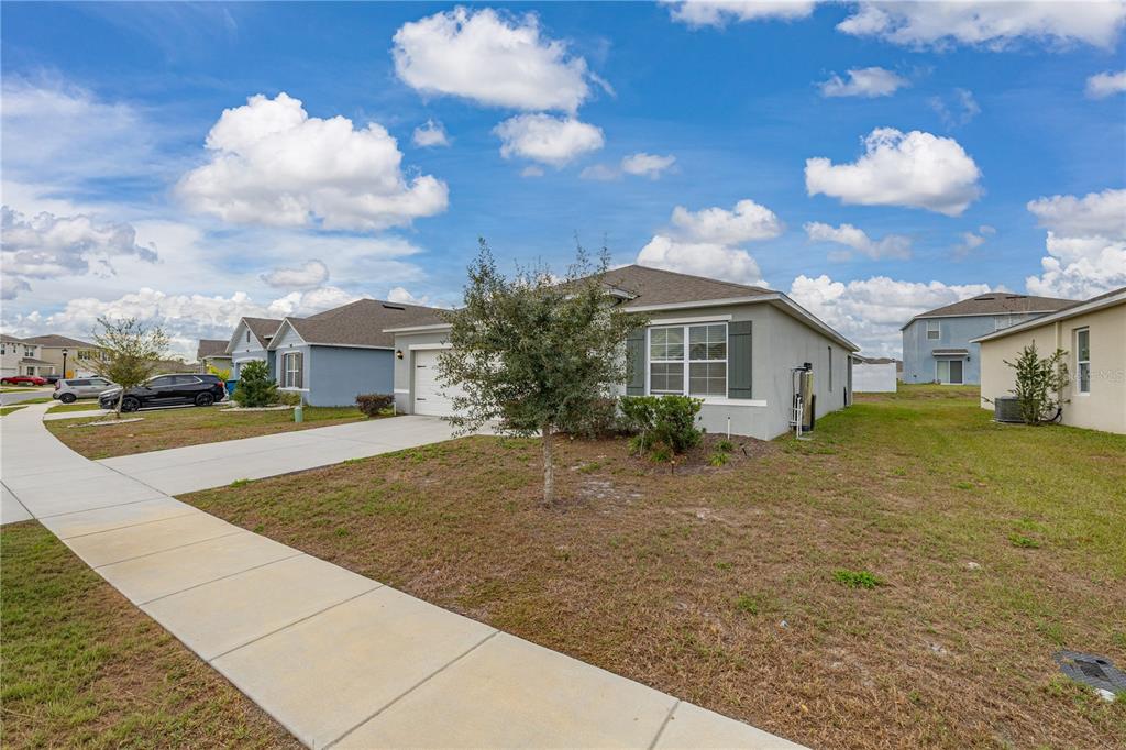 A single-story suburban house with a gray exterior, a two-car garage, and a concrete driveway — 624 HONEY BELL ROAD, WINTER HAVEN, FL