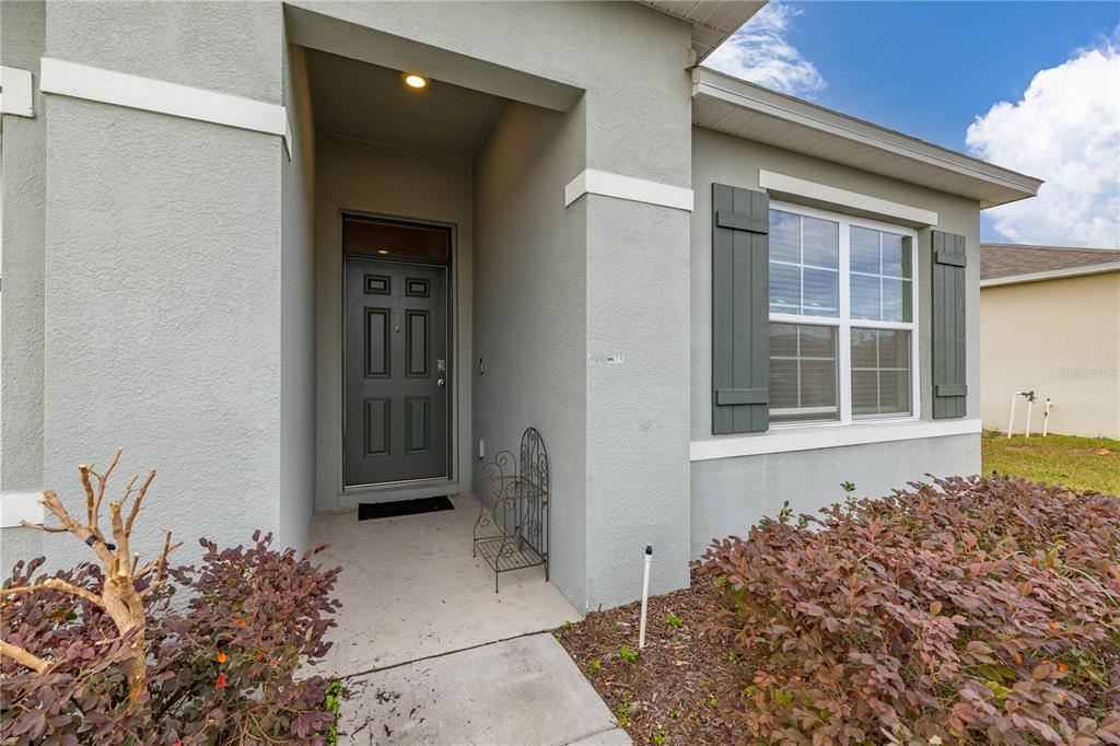 The exterior view shows a gray house with a covered entryway and dark green shutters — 624 HONEY BELL ROAD, WINTER HAVEN, FL