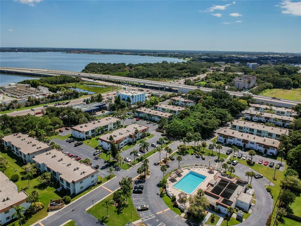 An aerial view shows a multi-building apartment complex with a swimming pool and parking lots — 379 S MCMULLEN BOOTH ROAD UNIT 75, CLEARWATER, FL