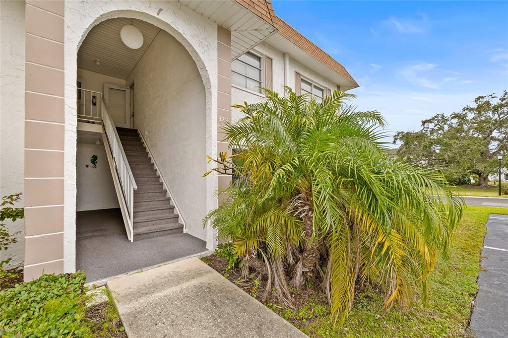 An exterior view of a building entrance with stairs leading to an upper level — 379 S MCMULLEN BOOTH ROAD UNIT 75, CLEARWATER, FL
