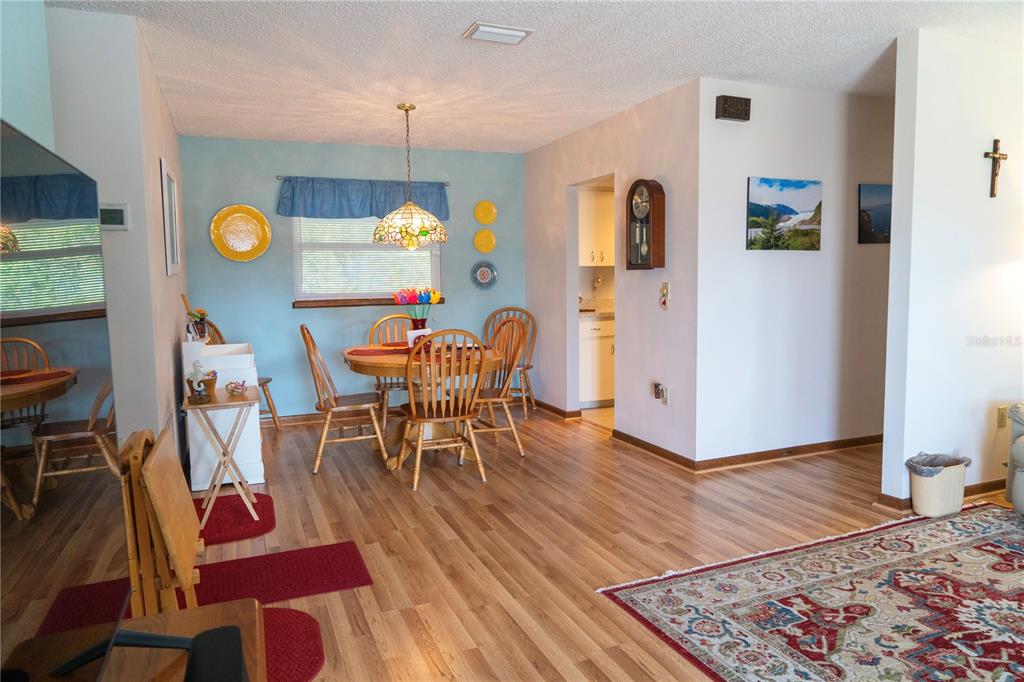 A dining area with a wooden table, chairs, and light blue walls on wood flooring — 10041 SW 97TH COURT, OCALA, FL