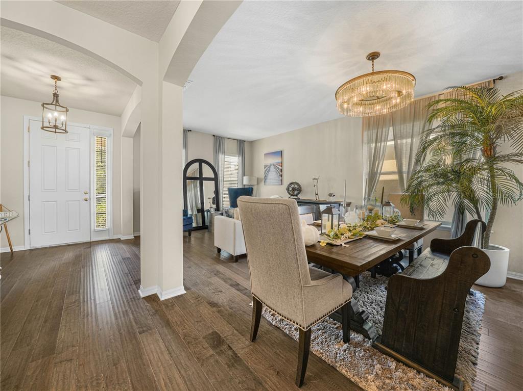 A kitchen with dark cabinets, a granite island, and a dining area with marble wall — 184 WHIRLAWAY DRIVE, DAVENPORT, FL