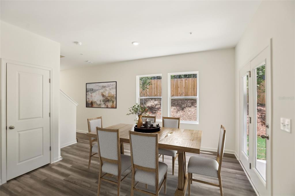 A dining room features a wooden table, four chairs, light-colored walls, and wood-look flooring — 2570 GREY HAWK DRIVE,, KISSIMMEE, FL