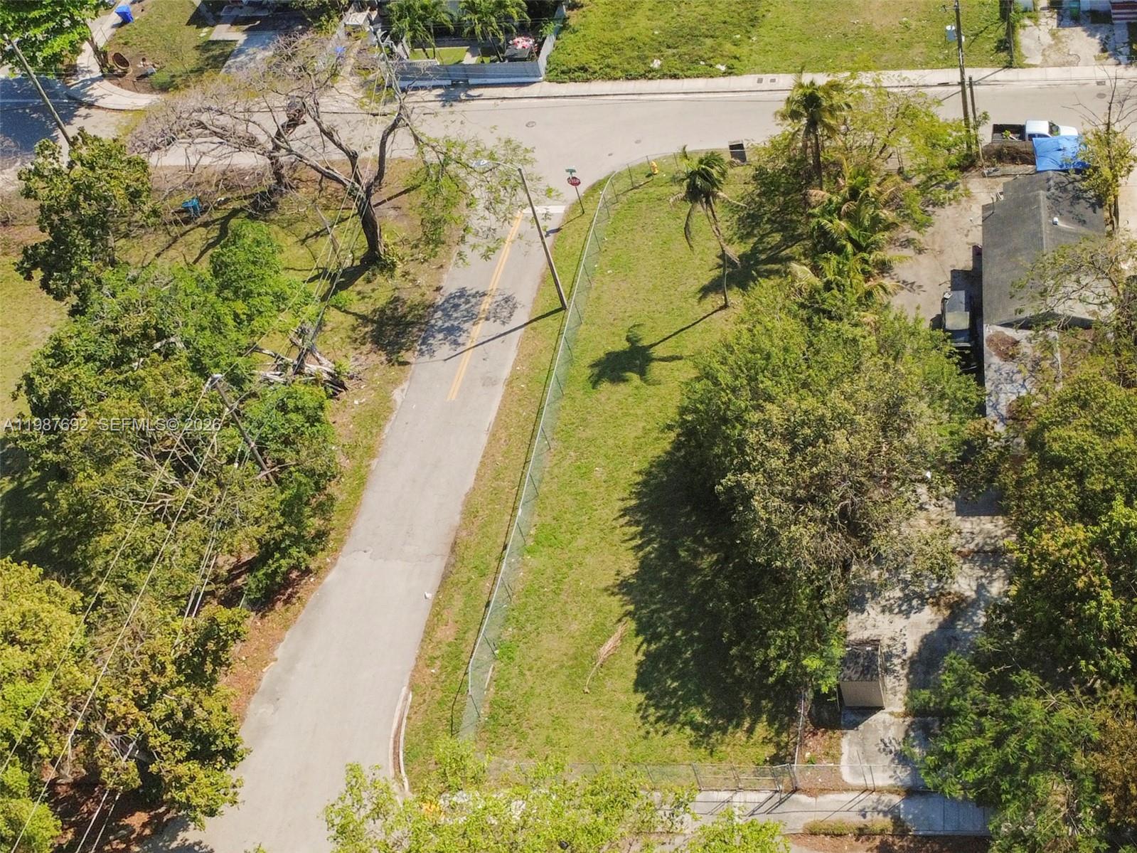 An aerial view shows a fenced, grassy vacant lot adjacent to a paved road — 800 NW 30th St, Miami FL 33127, MIAMI, FL