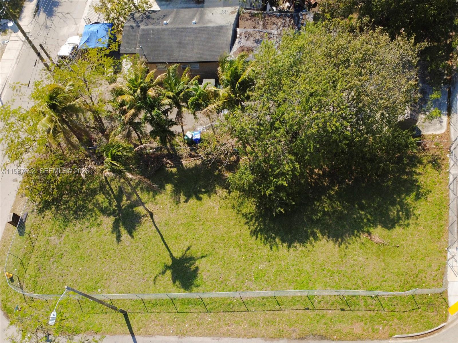 An aerial view shows a fenced, grassy vacant lot with several palm and shade trees — 800 NW 30th St, Miami FL 33127, MIAMI, FL