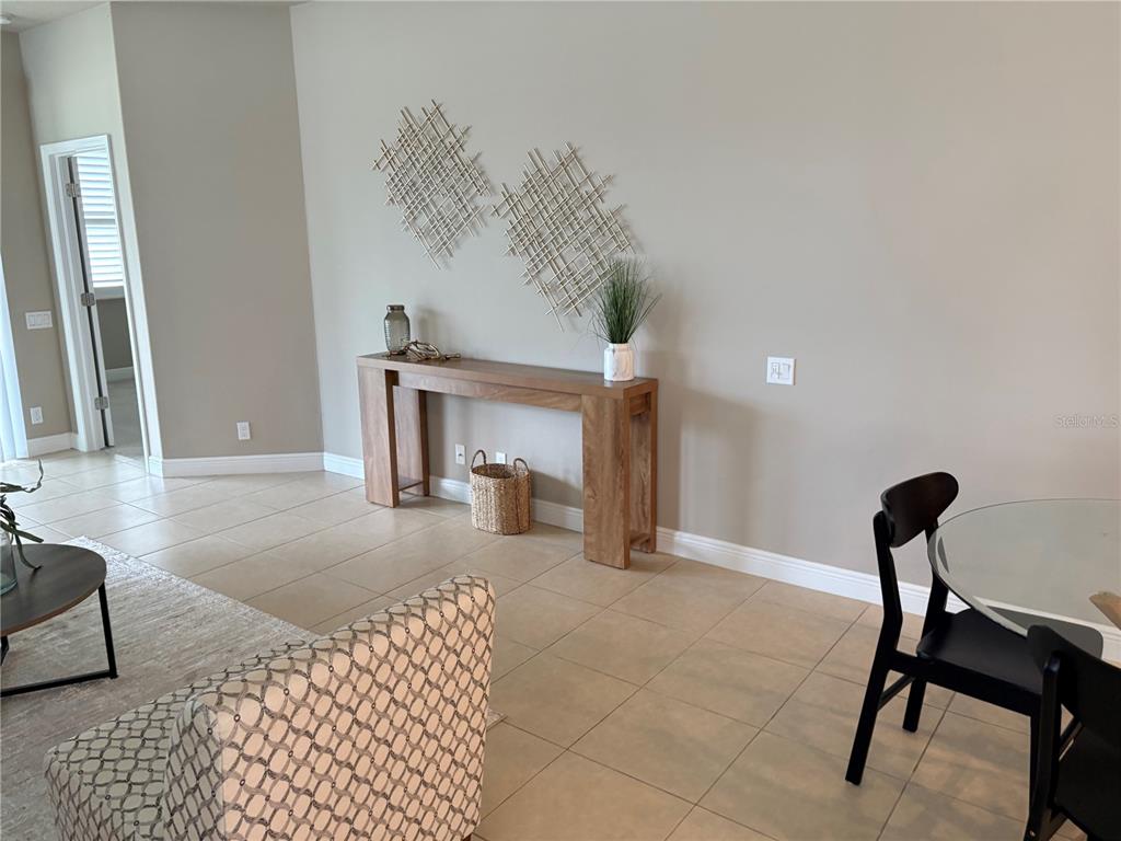 A living area features a wooden console table, wall art, and tile flooring — 14543 STRATHGLASS DRIVE, HUDSON, FL