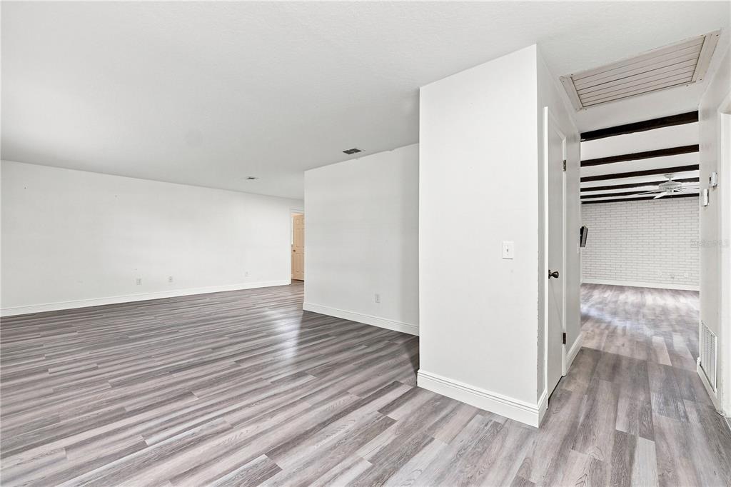 An interior view shows a room with gray wood-look flooring and white walls — 512 PONDEROSA DRIVE, ST CLOUD, FL