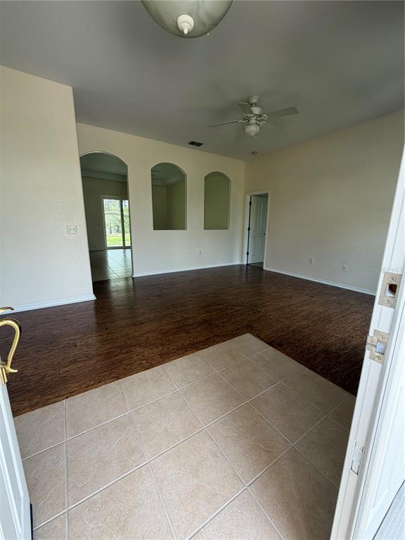 An entryway with tile flooring transitions into a living area featuring wood-look floors and niches — 18179 MABERLY  ROAD, WEEKI WACHEE, FL