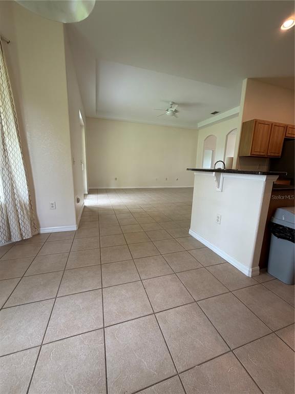 A view from a tiled kitchen area looking into an open-concept living room — 18179 MABERLY  ROAD, WEEKI WACHEE, FL