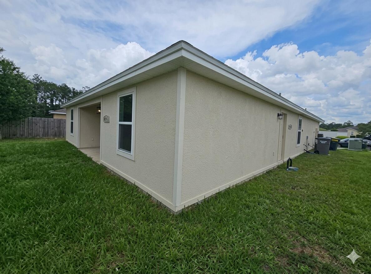 An aerial view shows a suburban house with solar panels on the roof and a driveway — 8650 W Lake George Cir W, FL 32063, FL