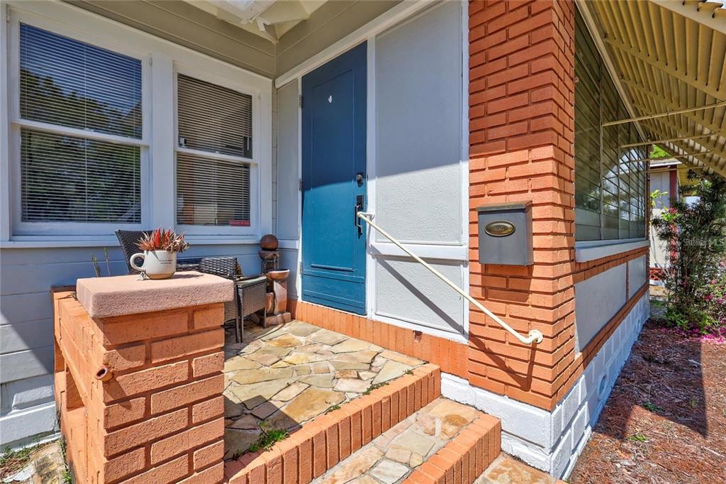 A front porch with brick pillars, a blue door, and a stone floor — 2521 4TH STREET S, ST PETERSBURG, FL