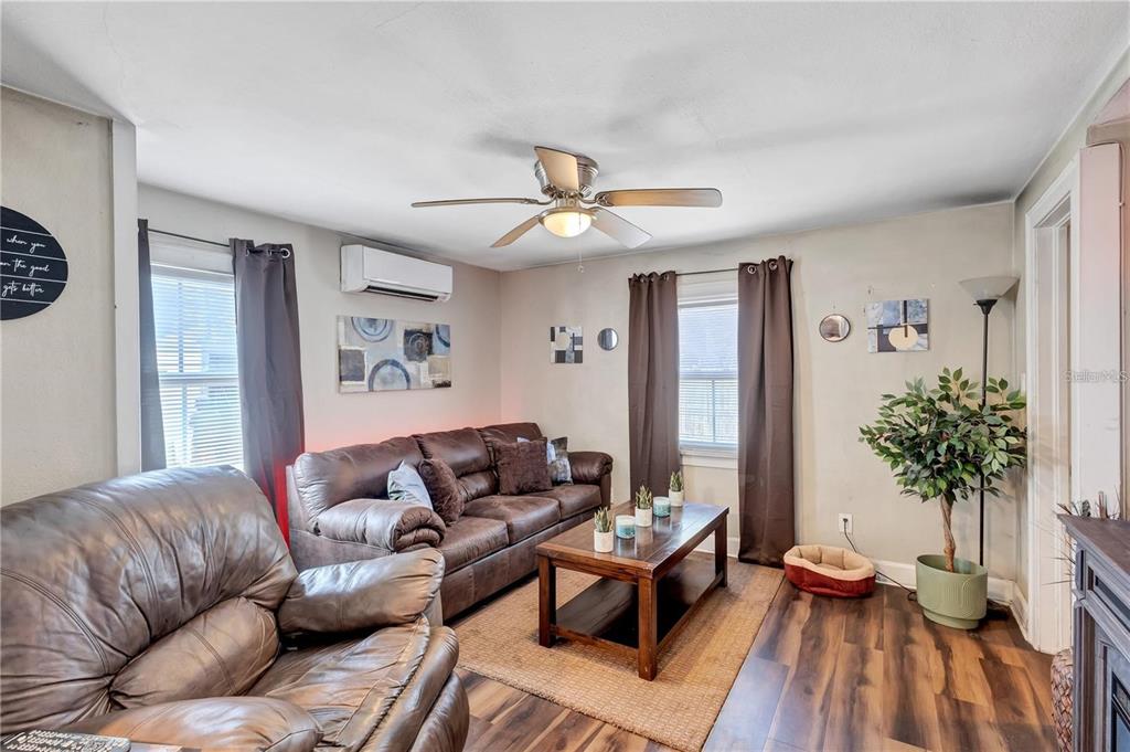 A living room features a brown leather sofa, matching armchair, coffee table, and ceiling fan — 2521 4TH STREET S, ST PETERSBURG, FL