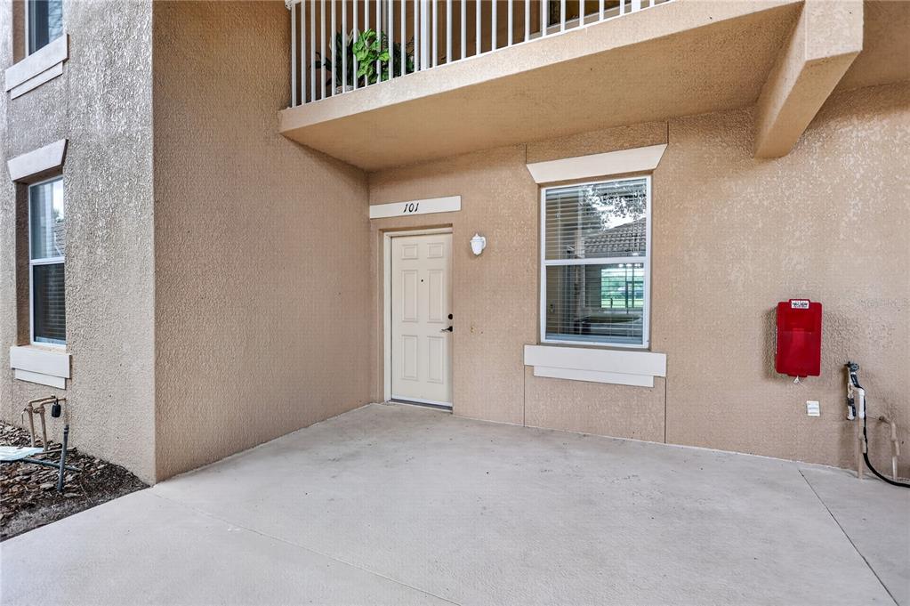 A covered parking space with a concrete floor and a silver car parked inside — 915 FAIRWAYCOVE LANE UNIT 101, BRADENTON, FL