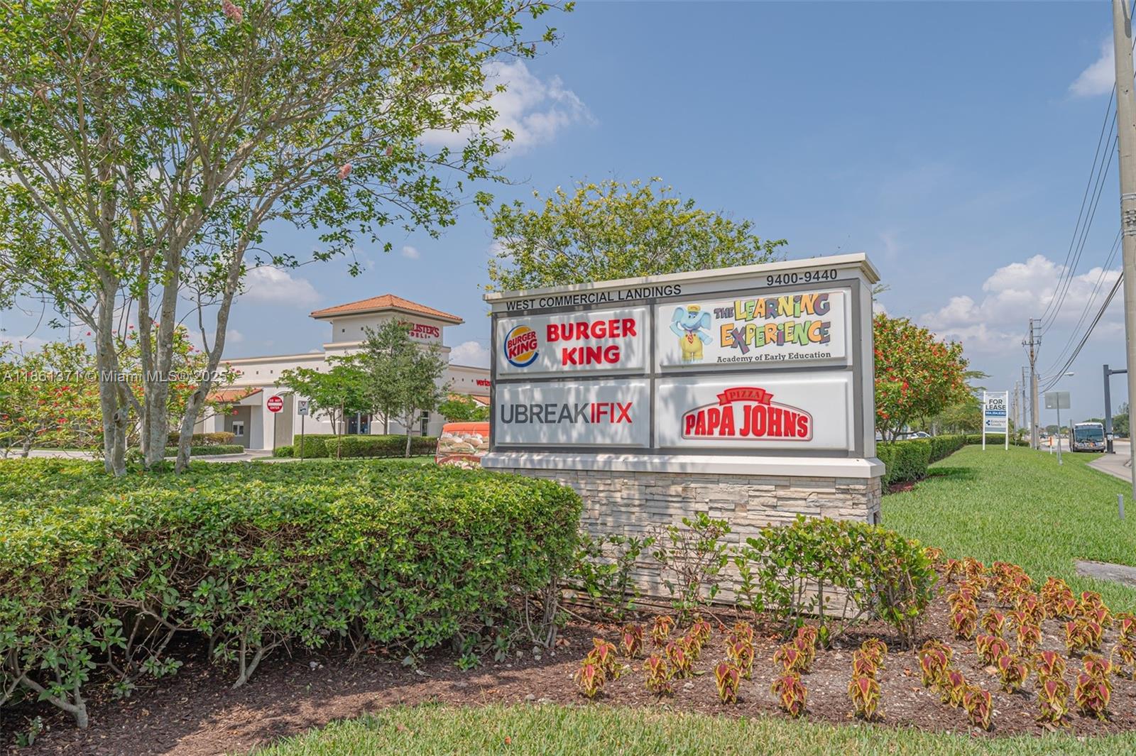 A commercial plaza sign lists several businesses in front of a landscaped parking lot — 9440 W Commercial Blvd, Sunrise FL 33351, SUNRISE, FL