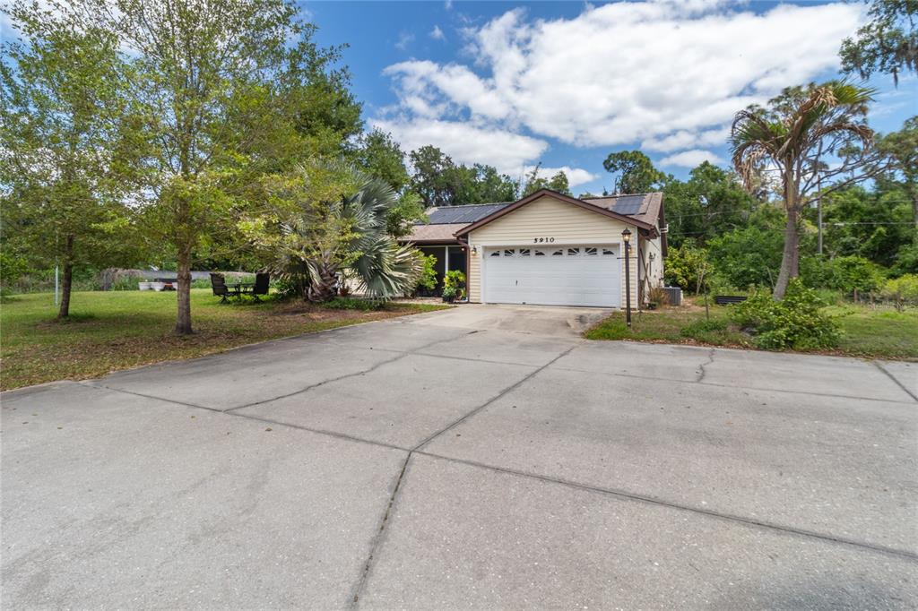 A single-story house with a two-car garage and a large concrete driveway — 5910 BELLA ROAD, PARRISH, FL