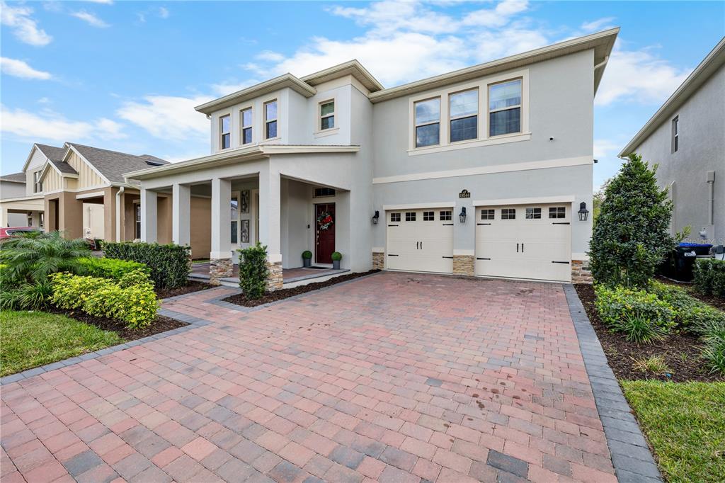 A two-story house with a paver driveway, a covered front porch, and a two-car garage — 18344 OLIVER TWIST WAY, WINTER GARDEN, FL
