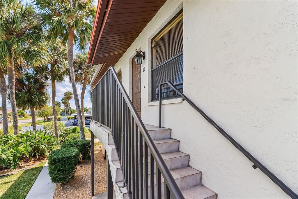 An exterior view of a building with a staircase leading up to a front door — 3935 COUNTRY CLUB BOULEVARD UNIT 17, CAPE CORAL, FL