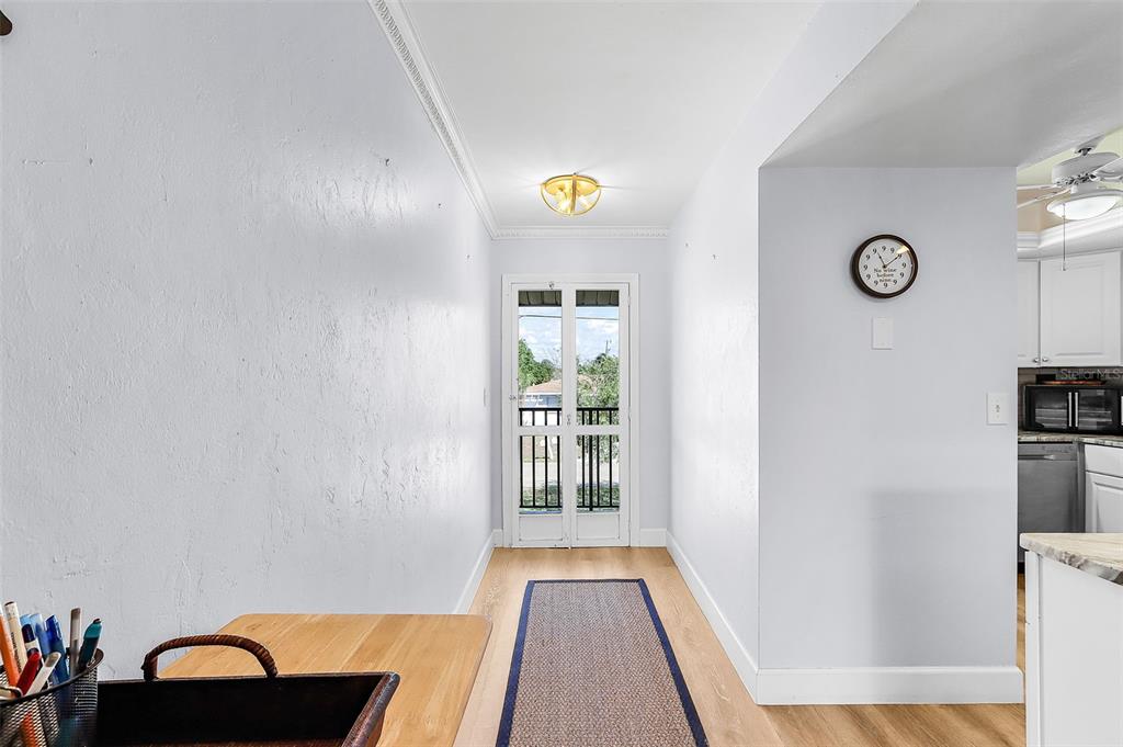 A bright hallway features light walls, wood flooring, a runner rug, and a glass-paneled door — 3935 COUNTRY CLUB BOULEVARD UNIT 17, CAPE CORAL, FL