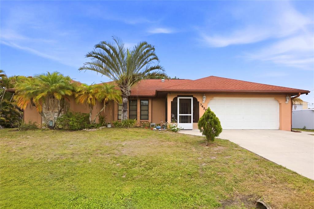 A single-story house with a tan exterior, red roof, and a palm tree in front — 3456 DWIGHT STREET, PORT CHARLOTTE, FL
