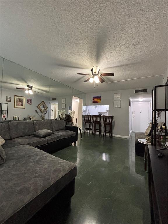 A living room features a large sectional sofa, mirrored walls, and a breakfast bar — 5820 N CHURCH AVENUE UNIT 348, TAMPA, FL