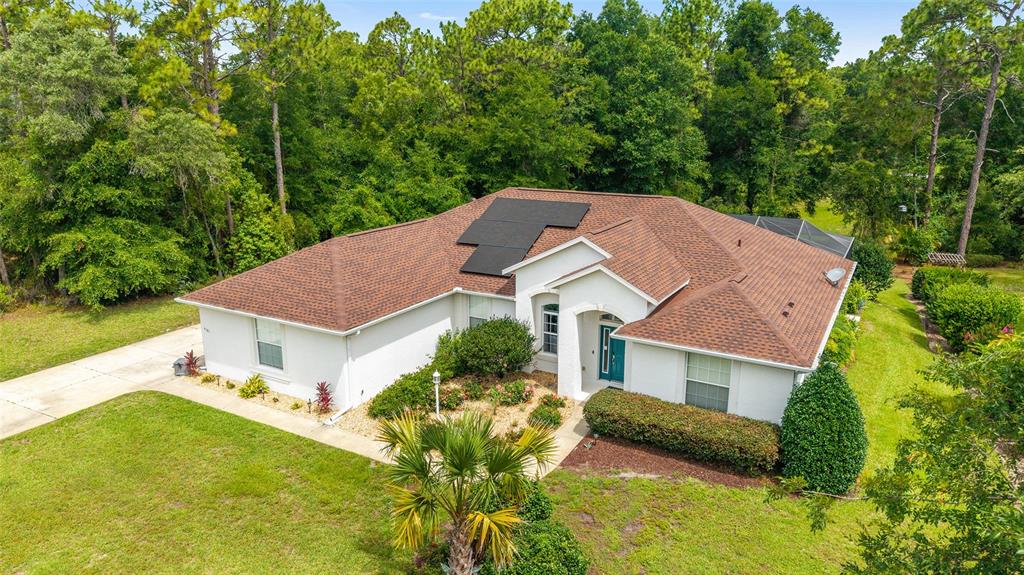 An aerial view shows a single-story house with a brown shingled roof and solar panels — 9781 SW 196TH CIRCLE, DUNNELLON, FL