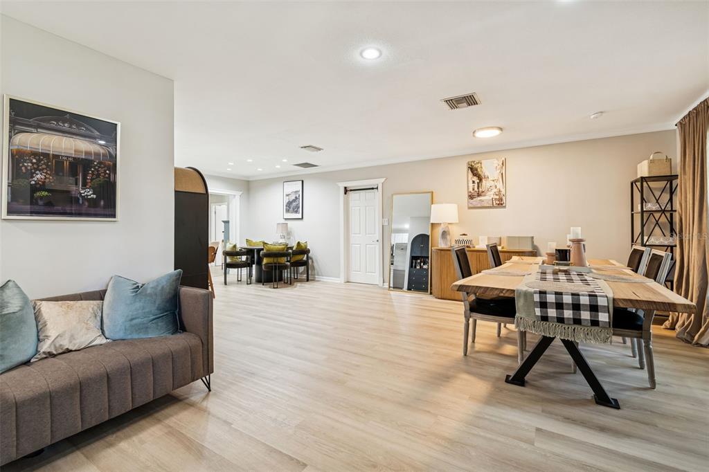 A dining room and living area feature light wood flooring, neutral walls, and modern furniture — 2302 S ARRAWANA AVENUE, TAMPA, FL
