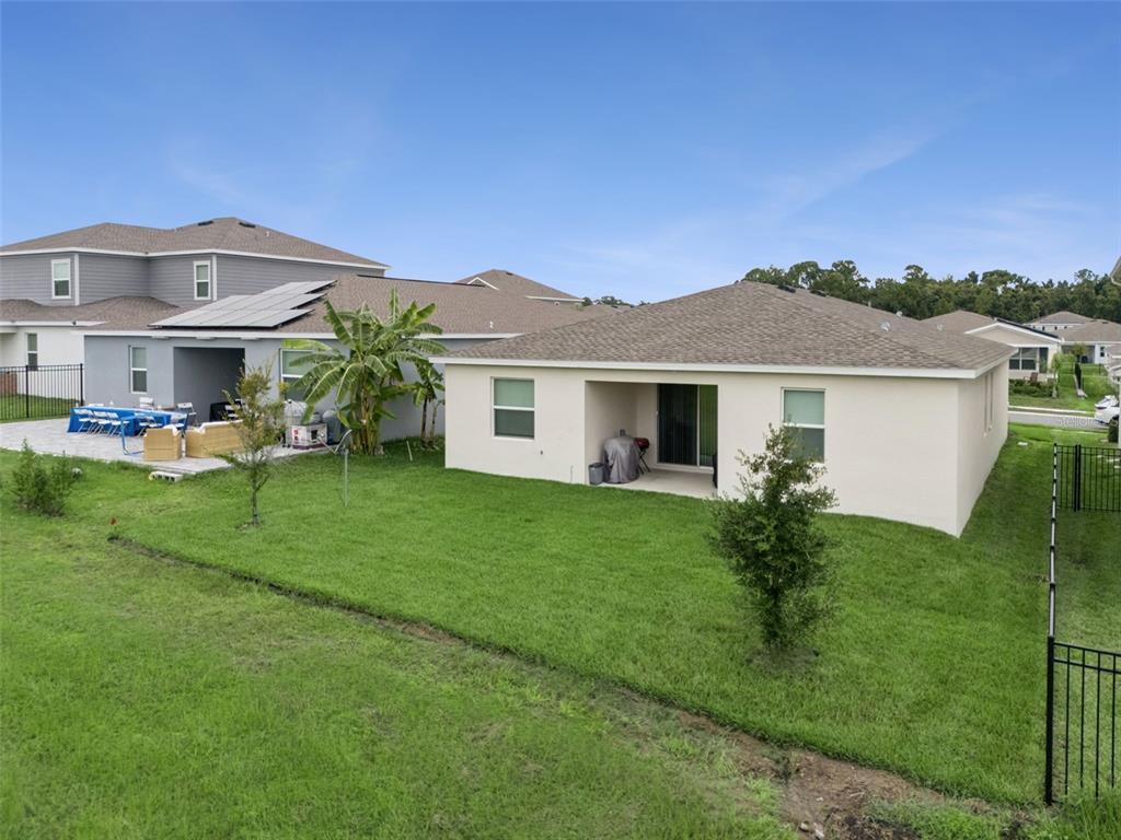 The exterior view shows the back of two suburban houses with lawns and a fence — 4614 WANDSWORTH WAY, DAVENPORT, FL