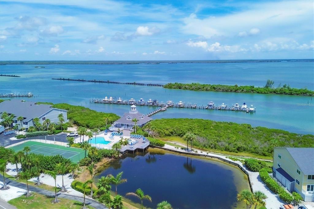 An aerial view shows a waterfront complex with a pool, tennis court, and boat docks — 6001 BOCA GRANDE CAUSEWAY UNIT E58, BOCA GRANDE, FL