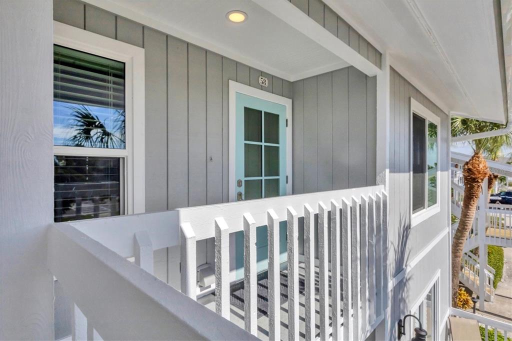 A light blue door with the number 58 sits on a balcony with white railings — 6001 BOCA GRANDE CAUSEWAY UNIT E58, BOCA GRANDE, FL