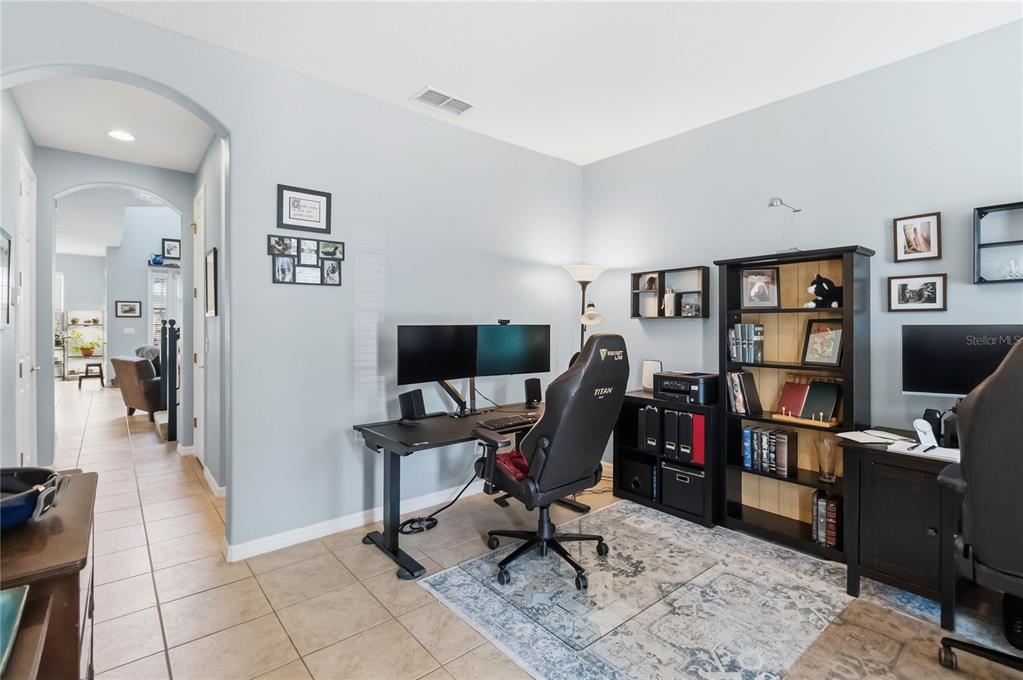 A home office features a desk with dual monitors, a gaming chair, and a bookshelf — 534 TERRACE SPRING DRIVE, ORLANDO, FL