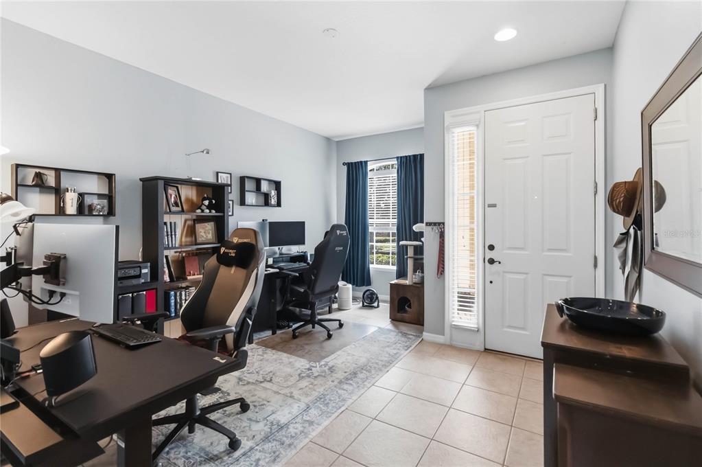 A home office with two desks, gaming chairs, a bookshelf, and a white entry door — 534 TERRACE SPRING DRIVE, ORLANDO, FL