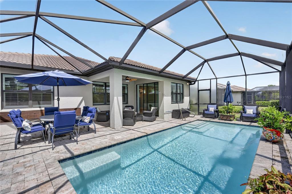 A screened-in patio features a swimming pool, outdoor furniture, and a covered seating area — 2633 DAISY DRIVE, NORTH PORT, FL