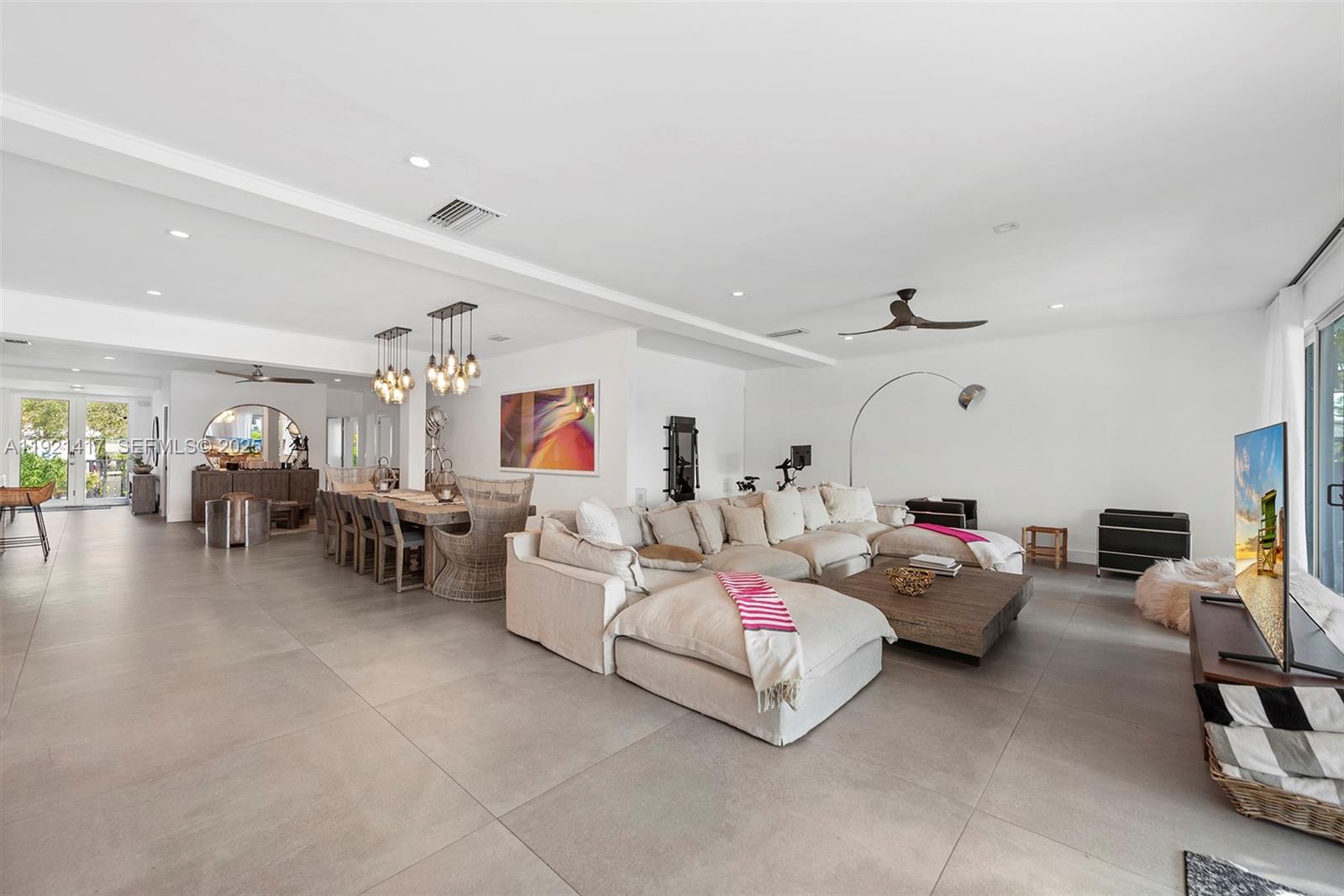A spacious open-concept living and dining area features light tile flooring and modern neutral furniture — 970 S Shore Dr, Miami Beach FL 33141, MIAMI BEACH, FL