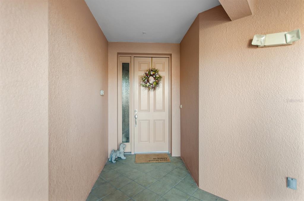 A front entryway features a beige door with a wreath, a sidelight, and tiled flooring — 5209 MANORWOOD DRIVE UNIT 3A, SARASOTA, FL