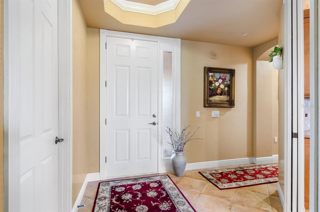 An entryway with tile floors, two red patterned rugs, a white door, and a skylight — 5209 MANORWOOD DRIVE UNIT 3A, SARASOTA, FL